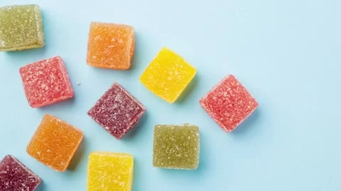 Stop motion of assorted jelly candies on blue background. Video stock 277871411