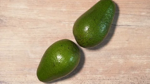 Stop motion the avocado in the form of a clock on a wooden countertop, a view Stock Footage 126143598