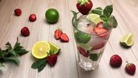 Stop motion big cocktail strawberry mojito on wooden table Video stock 156244458