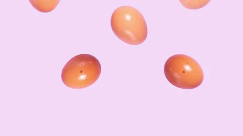 Stop motion brown chicken eggs falling down on purple background Stock Footage 138105138