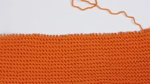 Stop motion close up animation unknitted texture. Orange knitted fabric Stock Footage 145832452