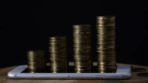 Stop motion coins stack increase on smart phone Stock Footage 98636329