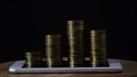 Stop motion coins stack increase on smart phone Stock Footage 98636348