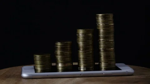Stop motion coins stack increase on smart phone Video stock 98636404