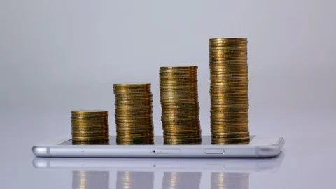 Stop motion coins stack increase on smart phone , business growth and success Stock Footage 98766612