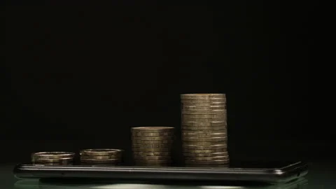 Stop motion a coins stack increase on smart phone rotation. business growth conc Stock Footage 170537918