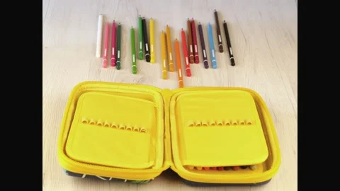 Stop motion of colored pencil going into a yellow pencil case Stock Footage 135254149