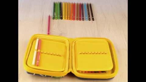 Stop motion of colored pencil going into a yellow pencil case Stock Footage 135254160