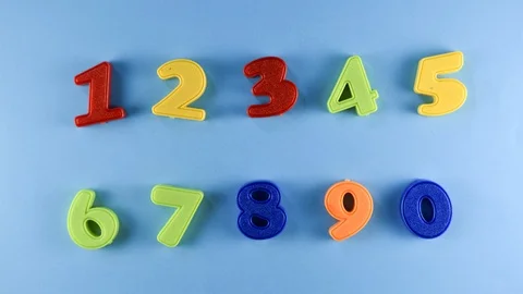 Stop Motion - Colorful plastic numbers wiggle or moving on a blue background Stock Footage 115095713