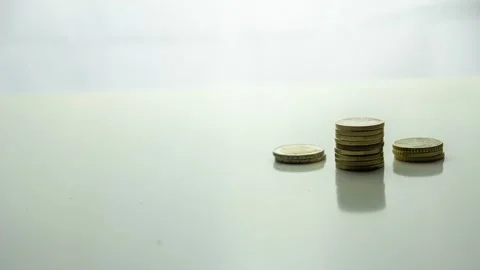 Stop motion concept save money. Hand putting coins in the table pile with the Stock Footage 139005457