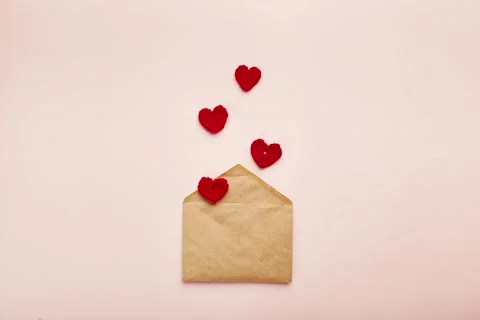 Stop Motion with Crocheted Red Hearts Floating from a Kraft Paper Envelope, Love Stock Footage 344043173