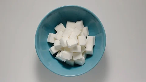 STOP MOTION: Cubes of white sugar appear in blue deep bowl Stock Footage 108573335