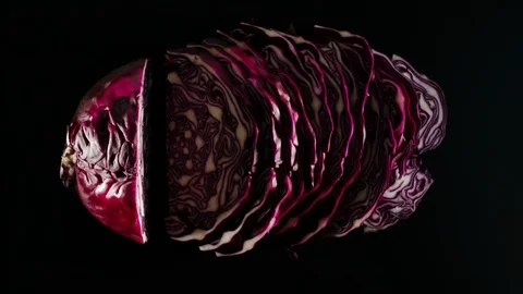 STOP MOTION: Cutting A Fresh Red Cabbage On A Black Surface Stock Footage 115958440