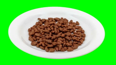 Stop Motion drops chocolate rice on a white plate Stock Footage 154552783