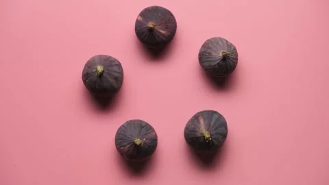 Stop motion with figs on a pink background moves and recreates itself. Stock Footage 161366276