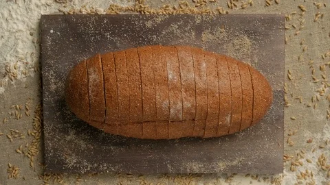 Stop motion of fresh bread's slices disappearing and appearing at wooden board. Video stock 125405118