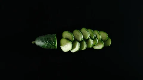 STOP MOTION: Fresh Green Cucumber Is Cutting On A Black Table Vídeo Stock 115958415