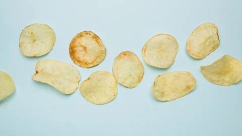 Stop motion of fried chips potato on blue background. Video stock 299325138