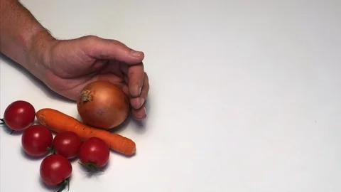 Stop motion of a hand that scatters many type of vegetables on a white table. Vidéo 98171510