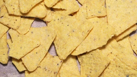 Stop motion harmful fast food, Mexican corn chips taken from wooden table Видео 125894556