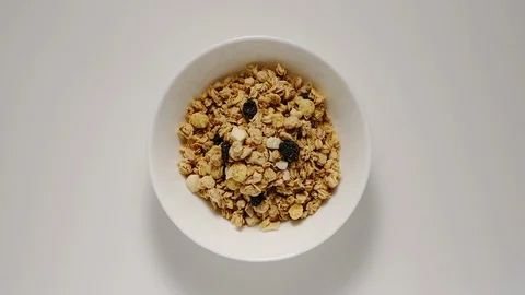 STOP MOTION: Heaps of muesli appear in white bowl Видео 108573302