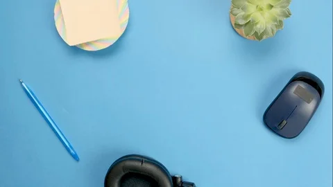 Stop motion with laptop on blue background. Objects moving in a circle. Telework Video stock 128596971