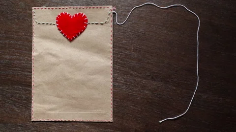 Stop Motion Love Letter Envelope with Red Heart Seal and Animating Thread Frame Stock Footage 335643441