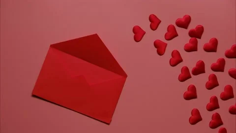 Stop motion of moving small red hearts in red envelope on pink background. Love Stock Footage 229584071