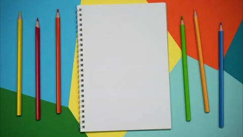 Stop motion of a notebook and colored pencils on colorful papers. Stop motion Stock Footage 264156476