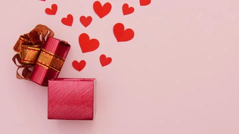 Stop motion of open gift box with red paper hearts floating on pink backgro.. Stock Footage 236732194