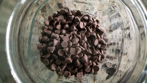 Stop motion overhead macro view of chocolate chips emptying from jar 스톡 동영상 129293635