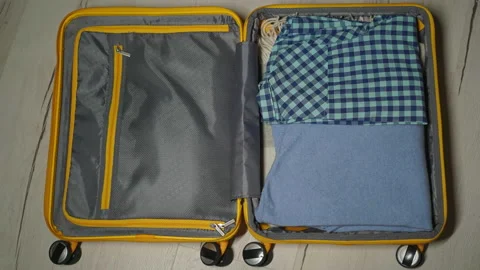Stop motion packing suitcase. Yellow plastic travel bag. Clothes for a trip. Видео 171091627