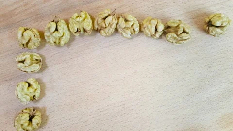 Stop motion. Peeled walnuts are framed. Walnut frame on a wooden surface. Stock Footage 144849843