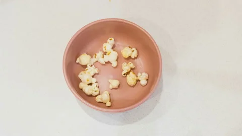 Stop Motion. Popcorn is poured into a pink bowl. 動画素材 110757025