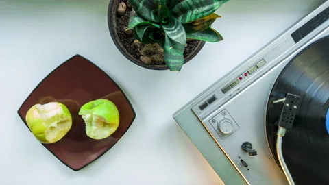 Stop motion pov vynil record player spinning, plate wit apples, eating two apple Stock-Footage 144428643