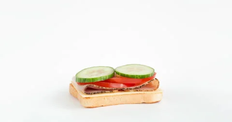 Stop motion of preparing sandwich with tomato, cucumber, salad, ham and cheese Stock Footage 170898078