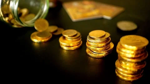 Stop motion reduction of a pile of gold coins, reduced investment and reduced Video stock 334027567