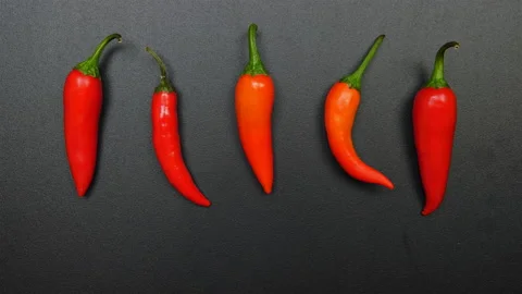 STOP MOTION: Shaking of a hot peppers on a black table Stock Footage 143882389