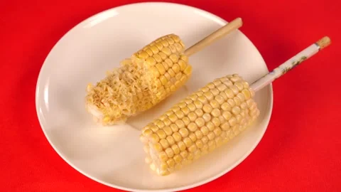 Stop motion shot of maize / Bhutta on a stick being eaten - a healthy diet Stock Footage 156778013