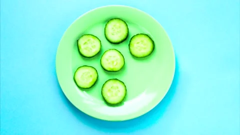 Stop motion of sliced fresh green cucumber moving and spreading on the plate Stock Footage 137719321