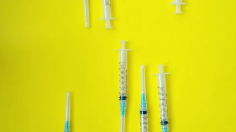 Stop motion syringes on yellow background Video stock 145543927