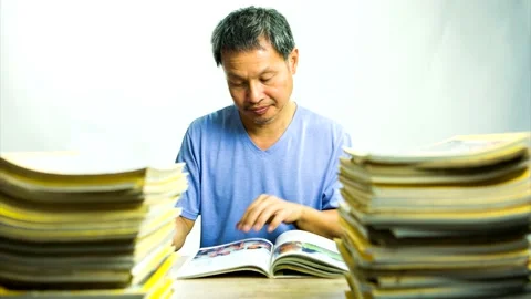 Stop motion of  Thai man  reading    book  with pile of books on the desk,  in s Stock Footage 147115580
