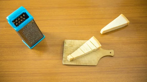 Stop motion of two triangular slices of grana cheese being grated. italian 스톡 동영상 244378642
