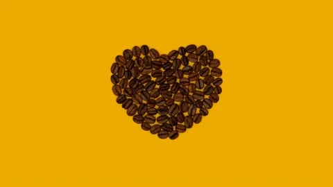 Stop motion video with coffee beans laid out in the shape of a heart on yellow. Stock Footage 237851919