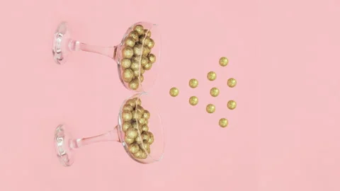 Stop motion video of Two champagne glasses filled with golden glitter decoration 스톡 동영상 144451228