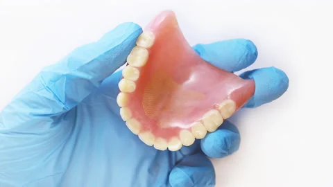 Stop motion video of Used acrylic denture in a gloved hand. Stock Footage 197817184