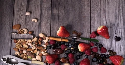 Stop motion view of berries amd dry fruits sliding on a wooden table Stock Footage 73131992