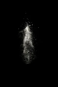 Stop motion of white dust explosion isolated on black background Stock Photos