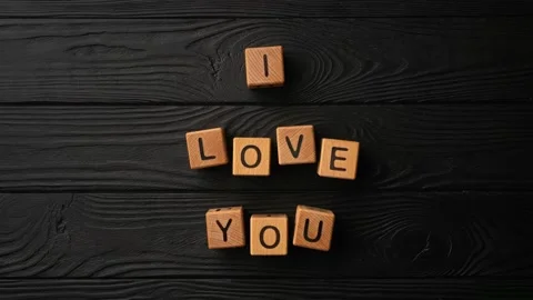 Stop-motion wooden cubes with the phrase I Love You on a black background - a Stock Footage 231998436