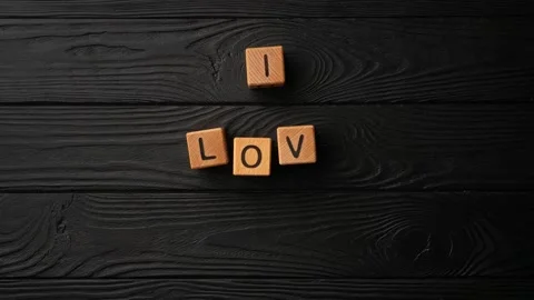 Stop-motion wooden cubes with the phrase I Love You on a black background - a Stock Footage 232000384